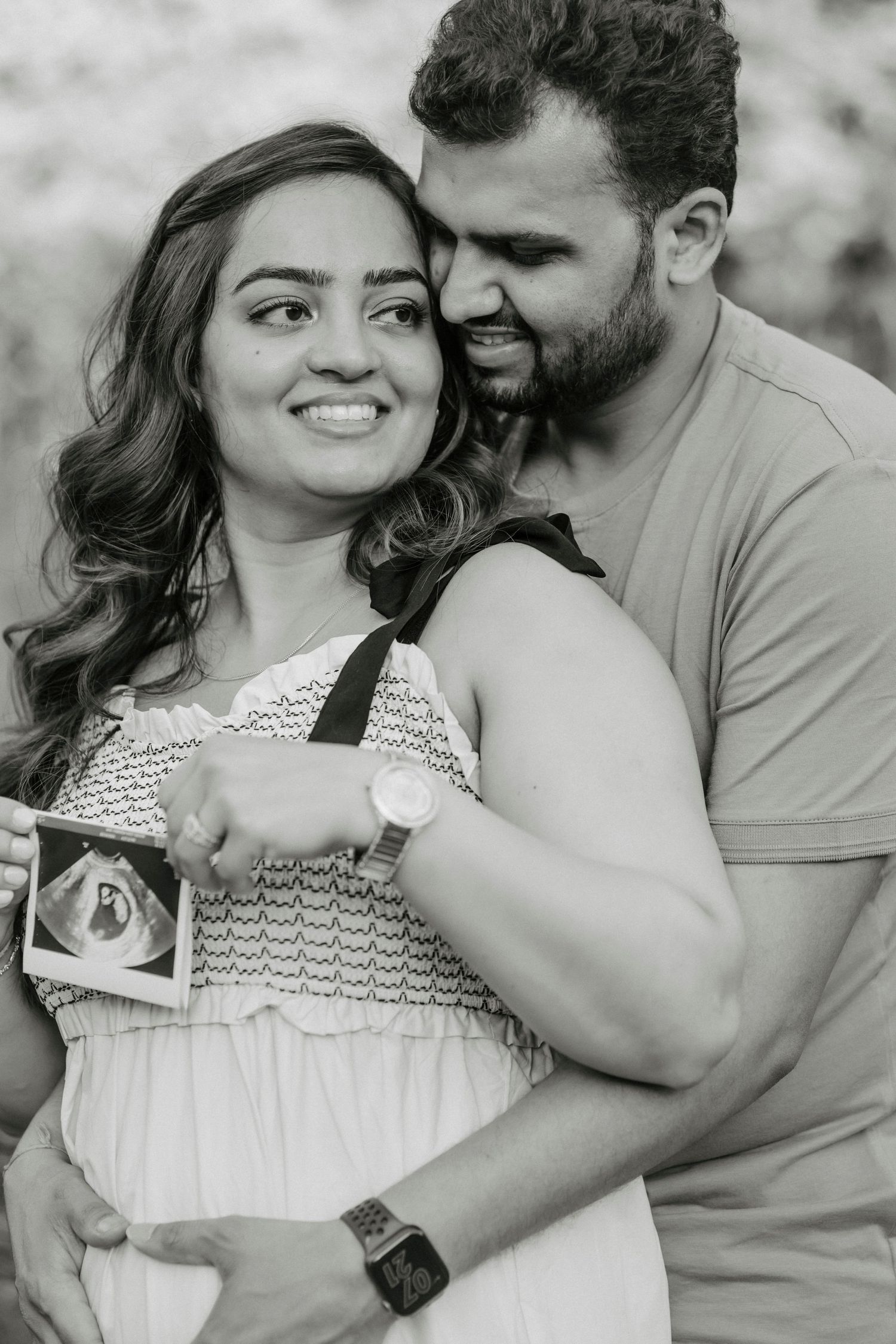 A romantic couple's portrait showing joyful expressions while holding an ultrasound photo.