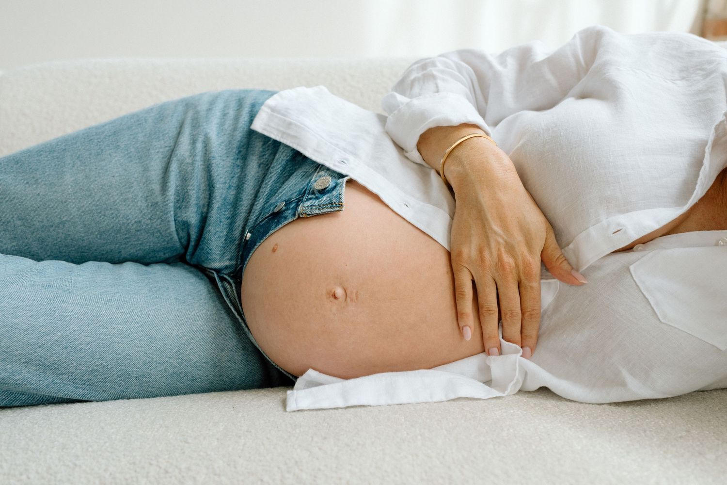 Black and white image showing an intimate pregnancy moment with a child touching a growing belly during maternity photoshoot in San Diego.