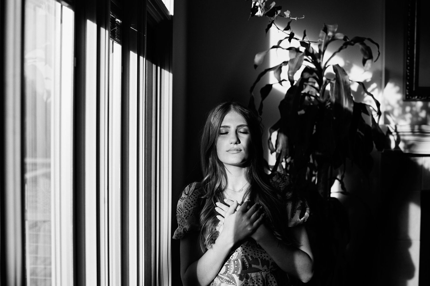 Dramatic black and white portrait series with window light and shadows.