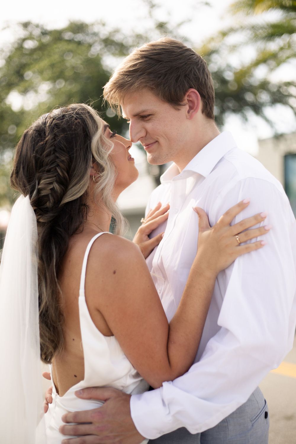 Joyful wedding couple shares an intimate moment outdoors.