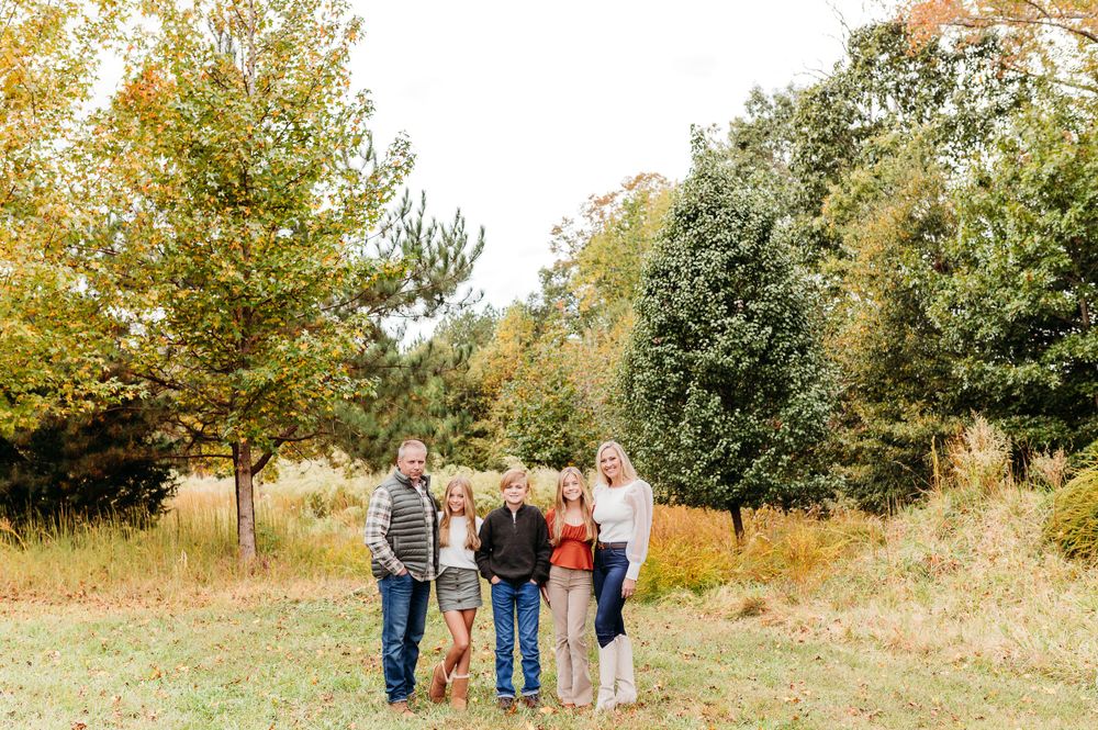 A series of fall outdoor family photos taken in a natural setting with golden autumn foliage and trees.