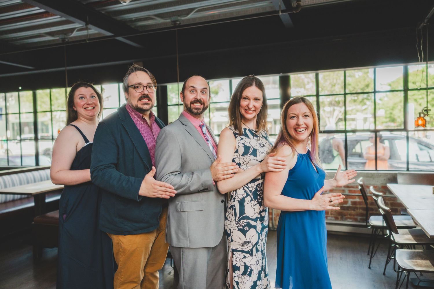 Wedding party posing together in an industrial-style venue.