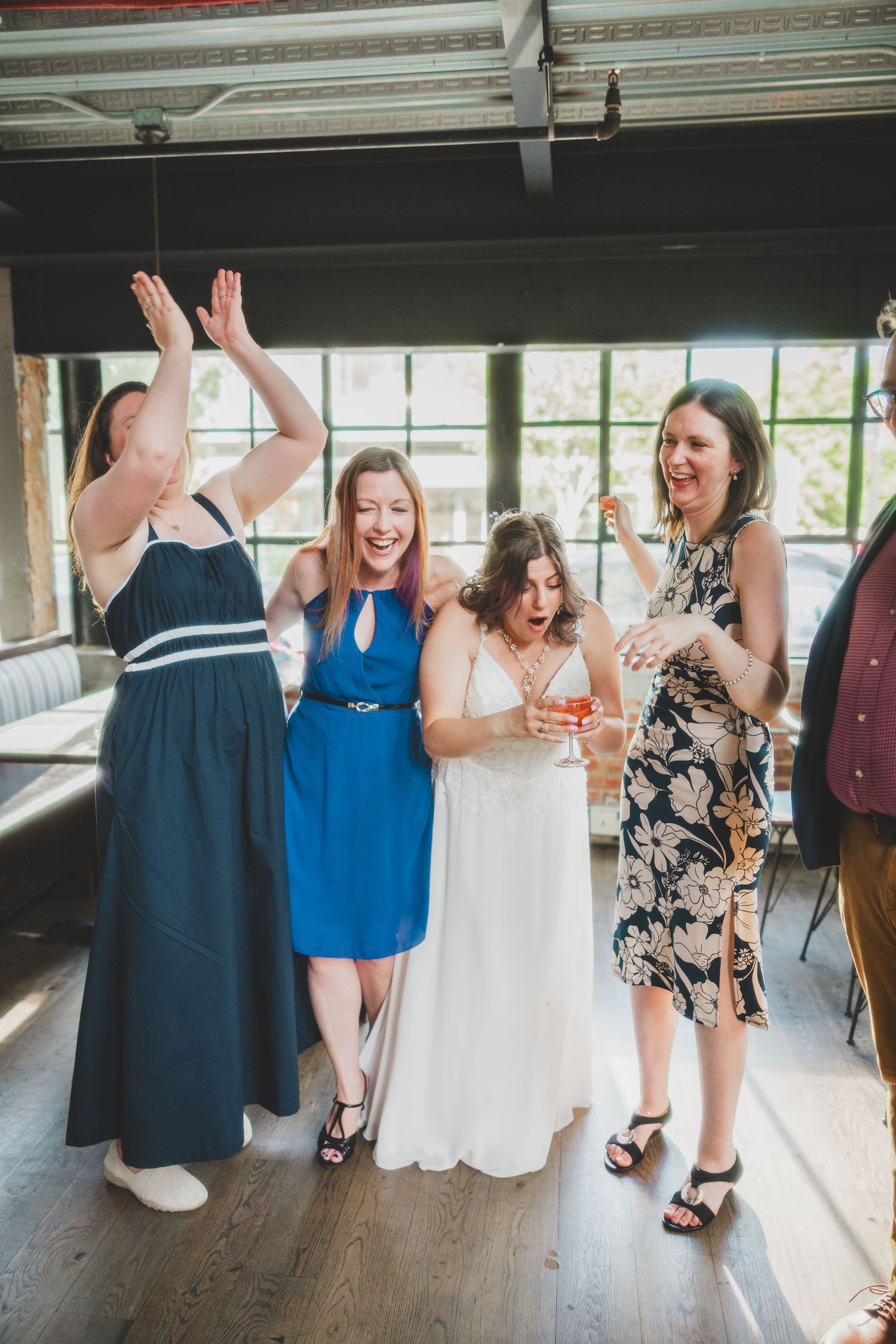 Women in elegant dresses celebrating at a wedding reception.