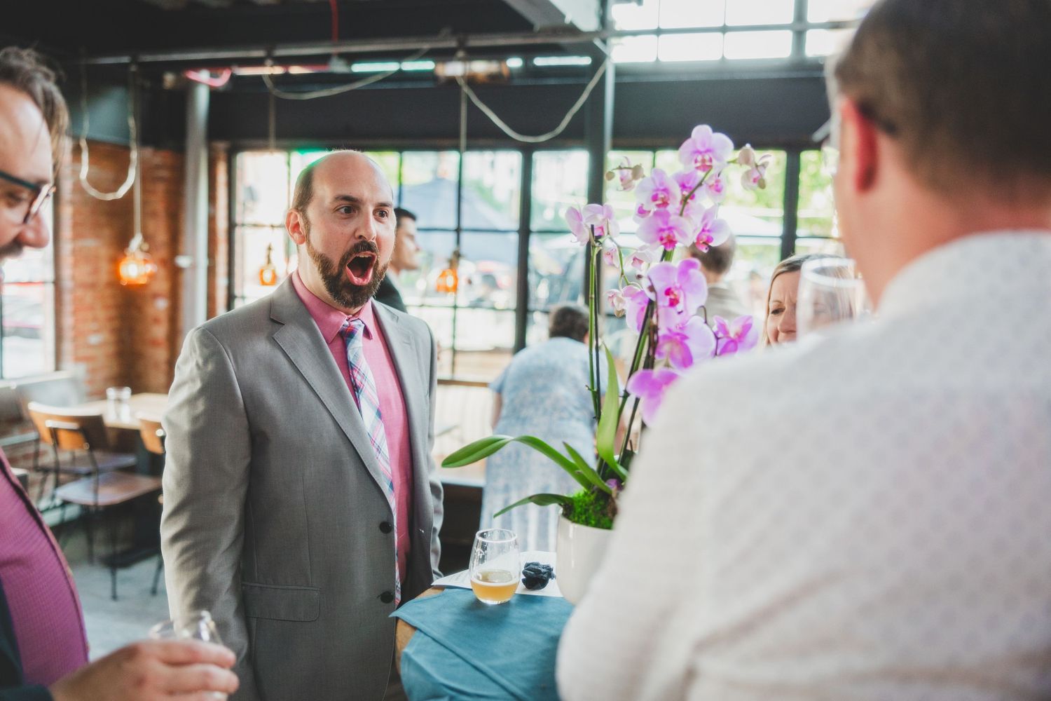 Wedding conversation near a pink orchid centerpiece.