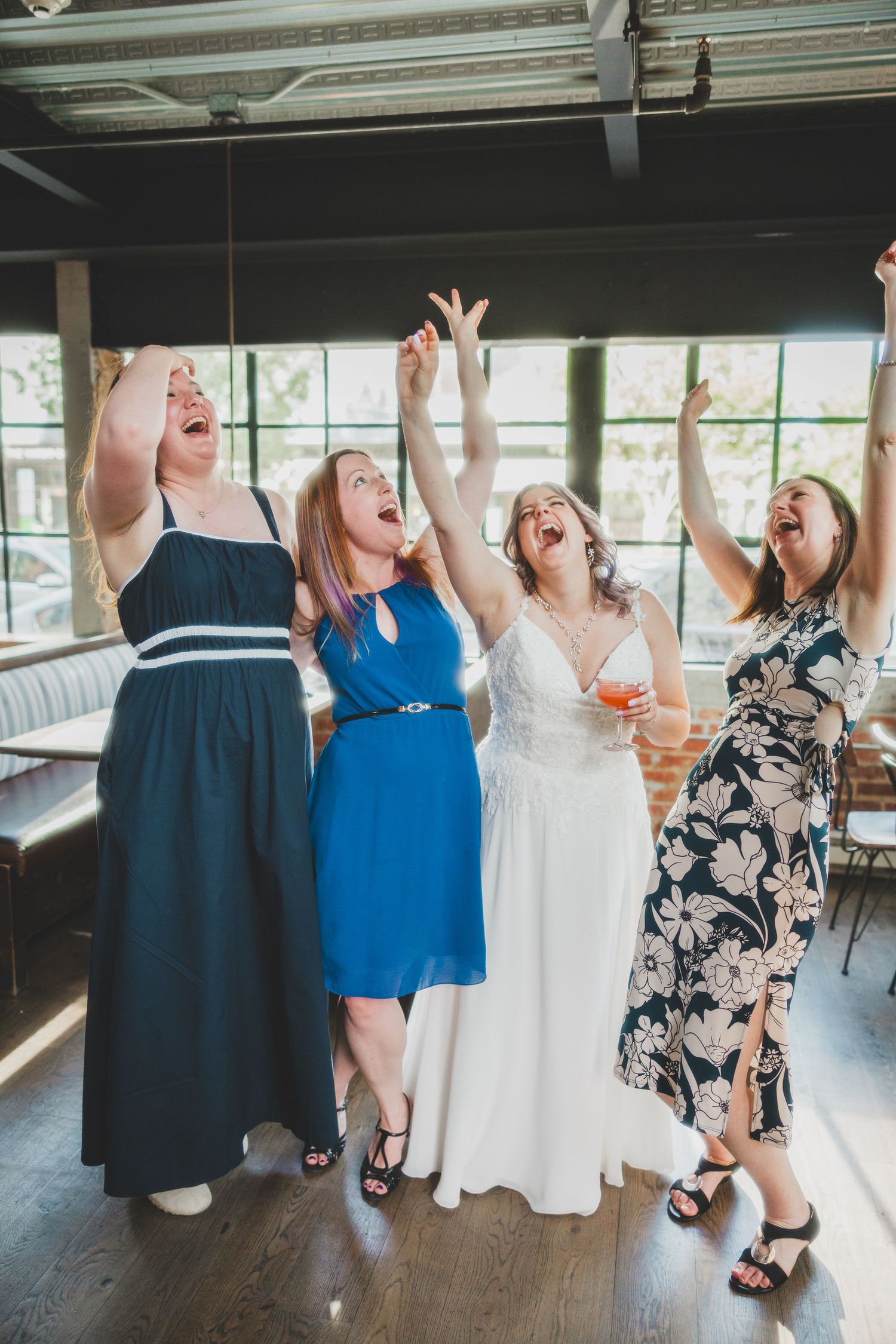 Wedding party celebrating joyfully together in a rustic venue.
