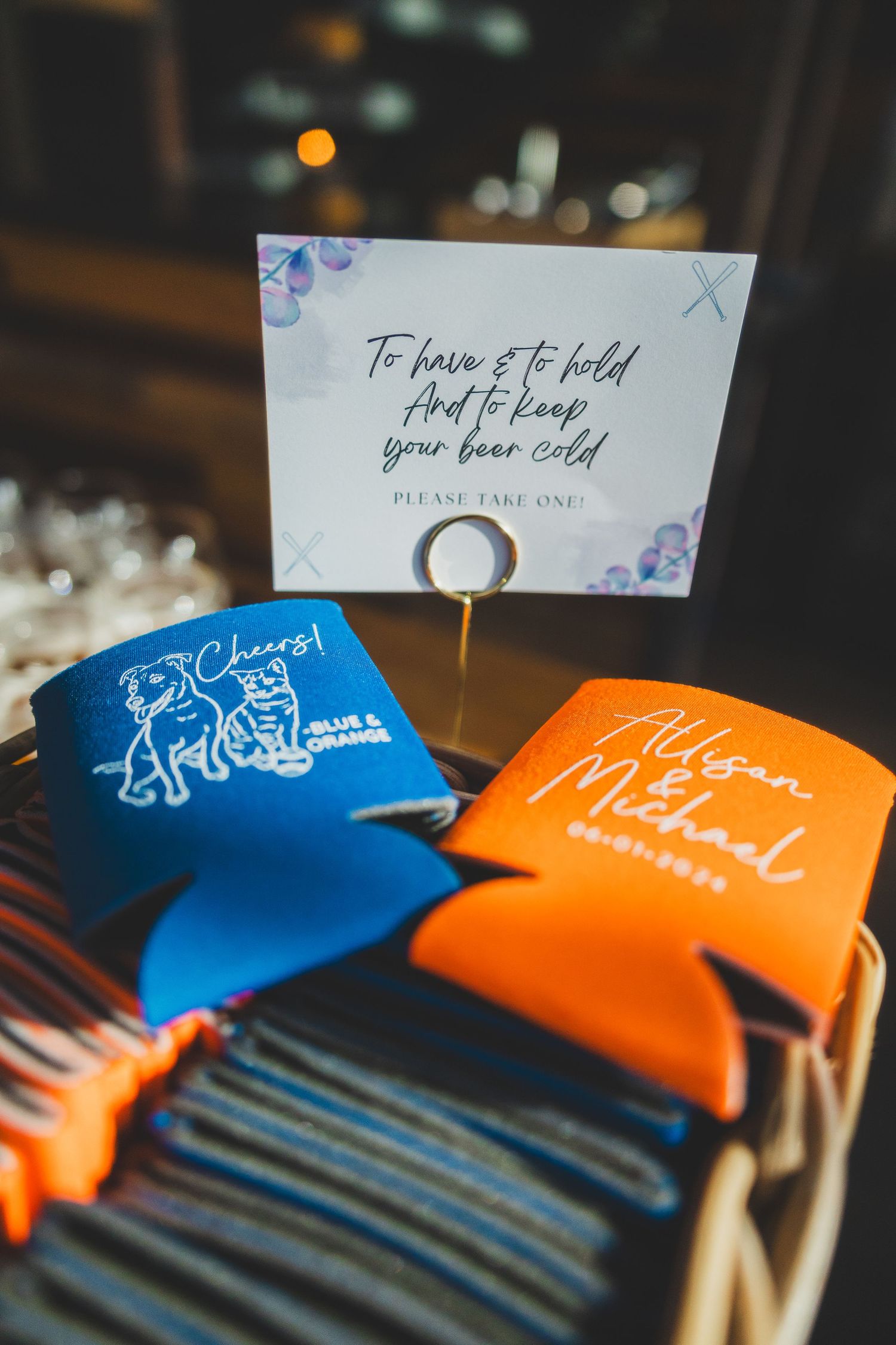 Blue and orange wedding koozies with a decorative card display.