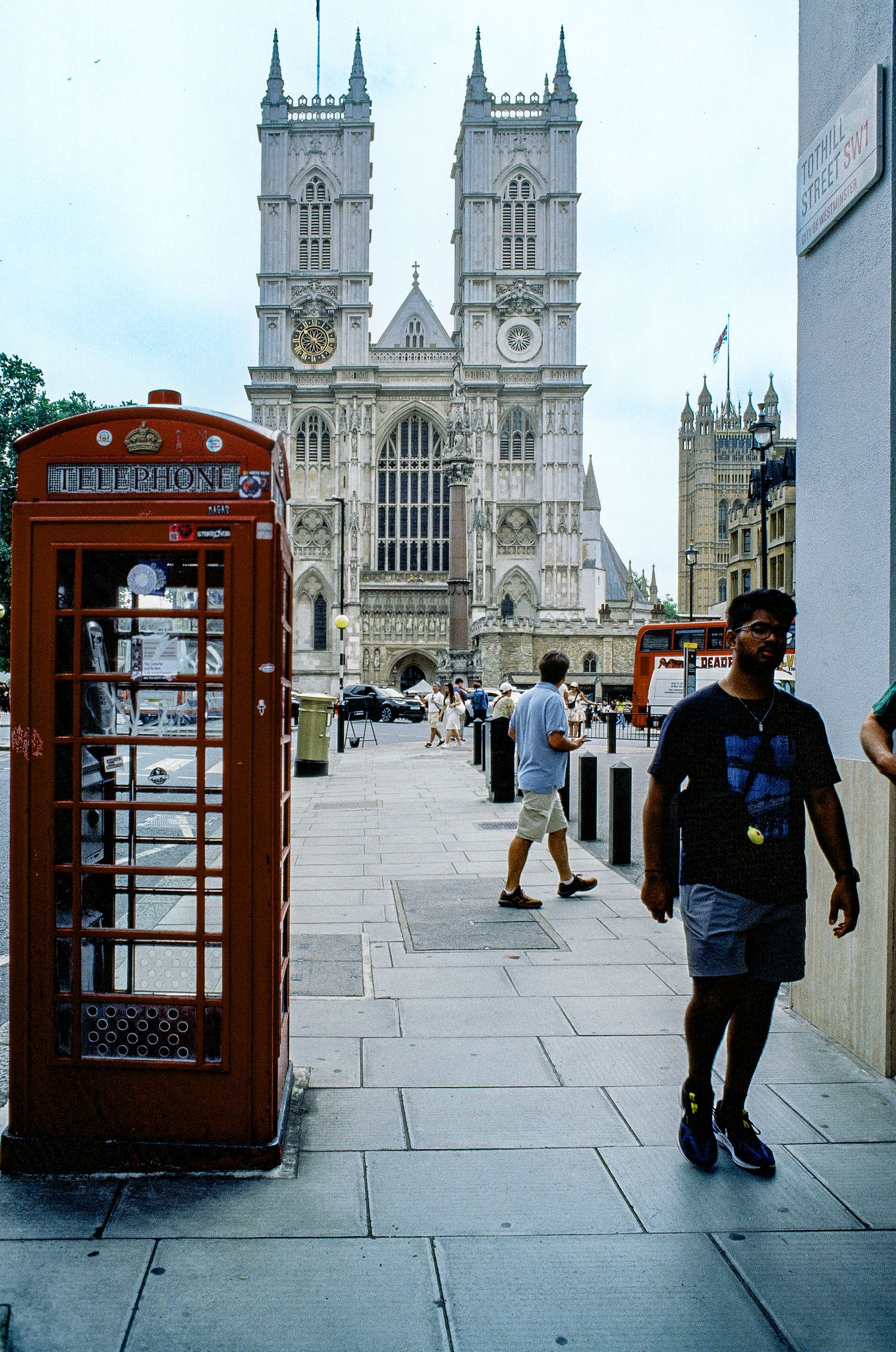 Westminster Abbey with iconic red phone booth and stone walkway in London.