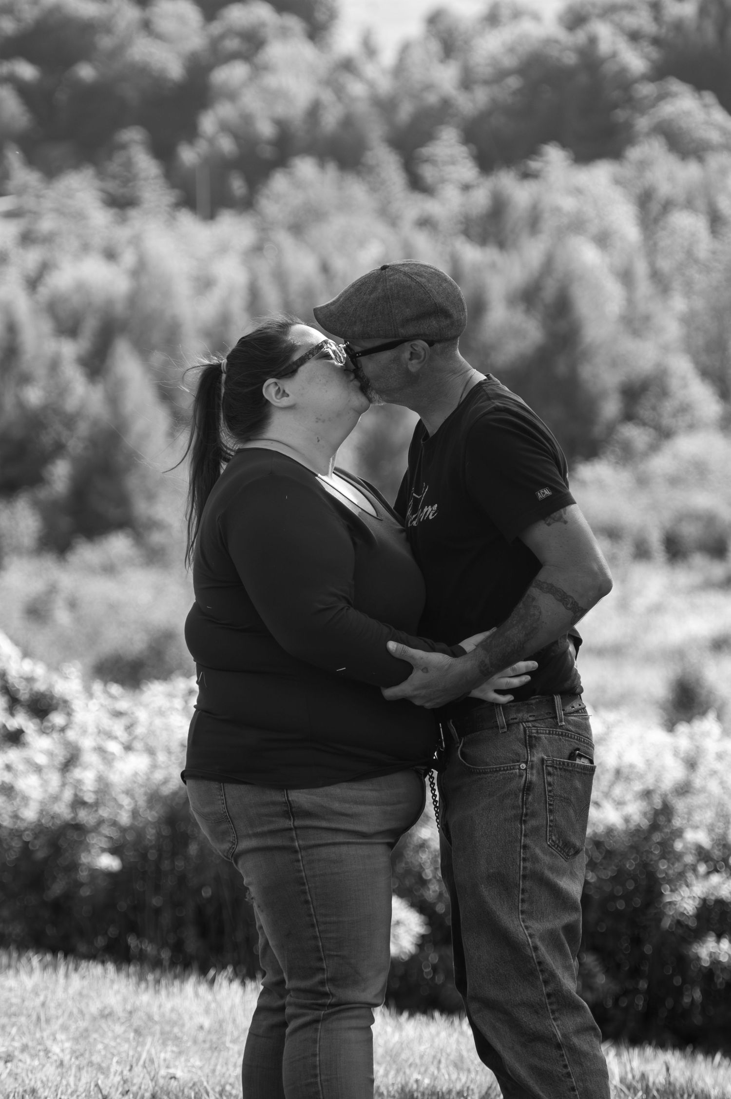 Black and white romantic moment captured in a scenic outdoor setting.