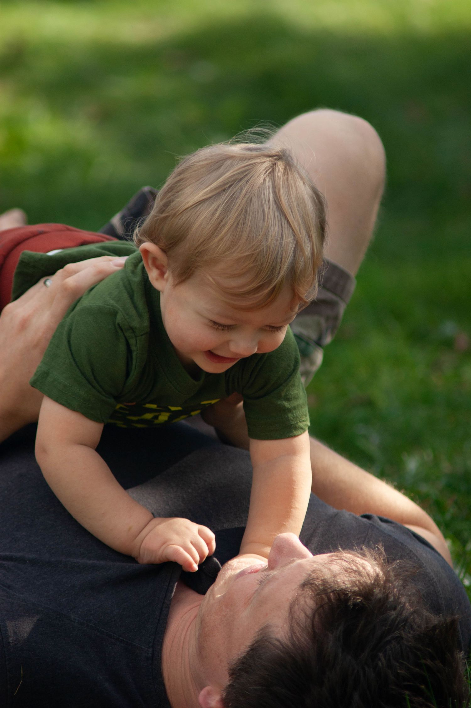 A playful moment captured outdoors on a sunny day in the grass.