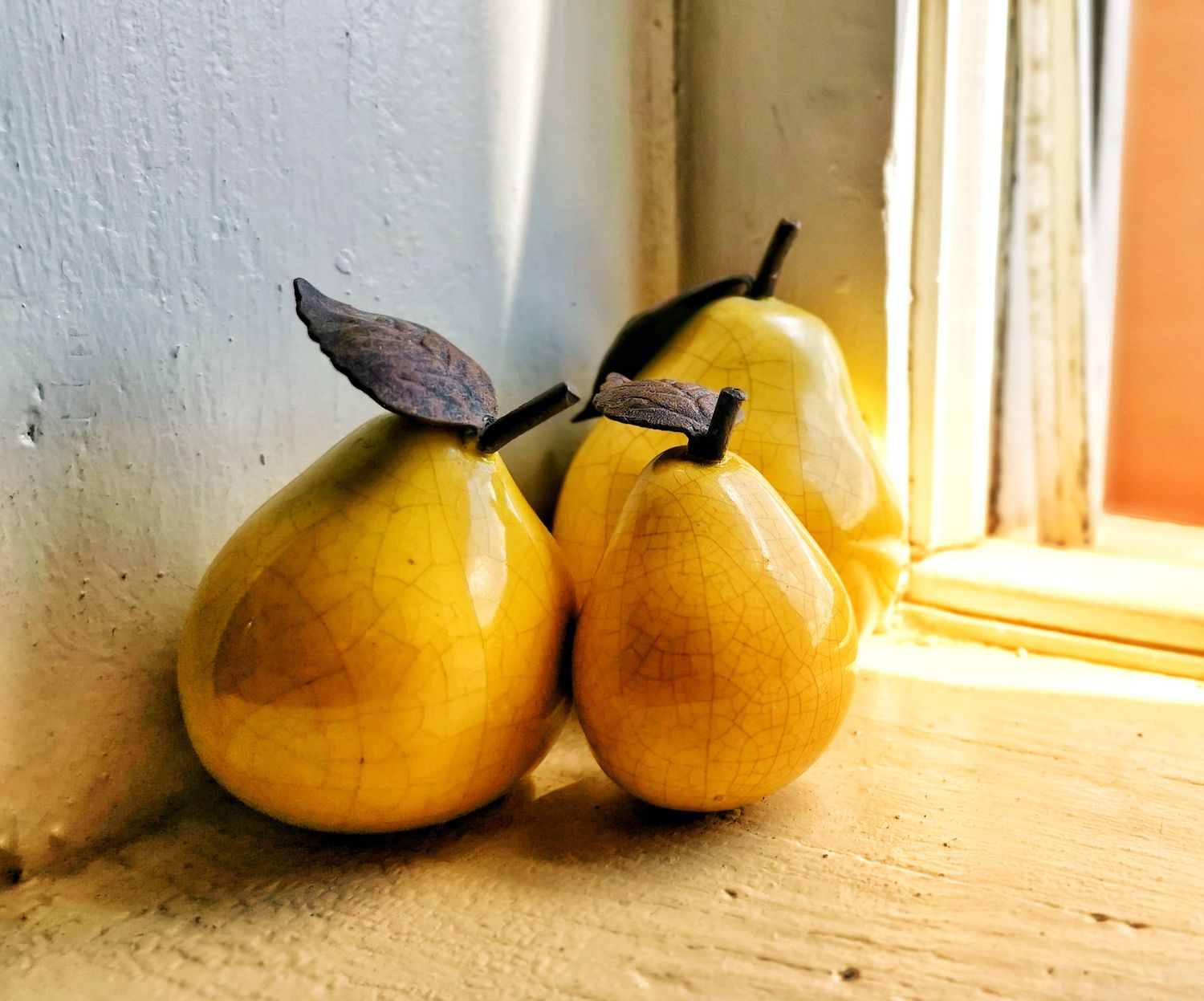 Still life photograph of polished ceramic pears on a windowsill, in downtown Columbus, Ohio.