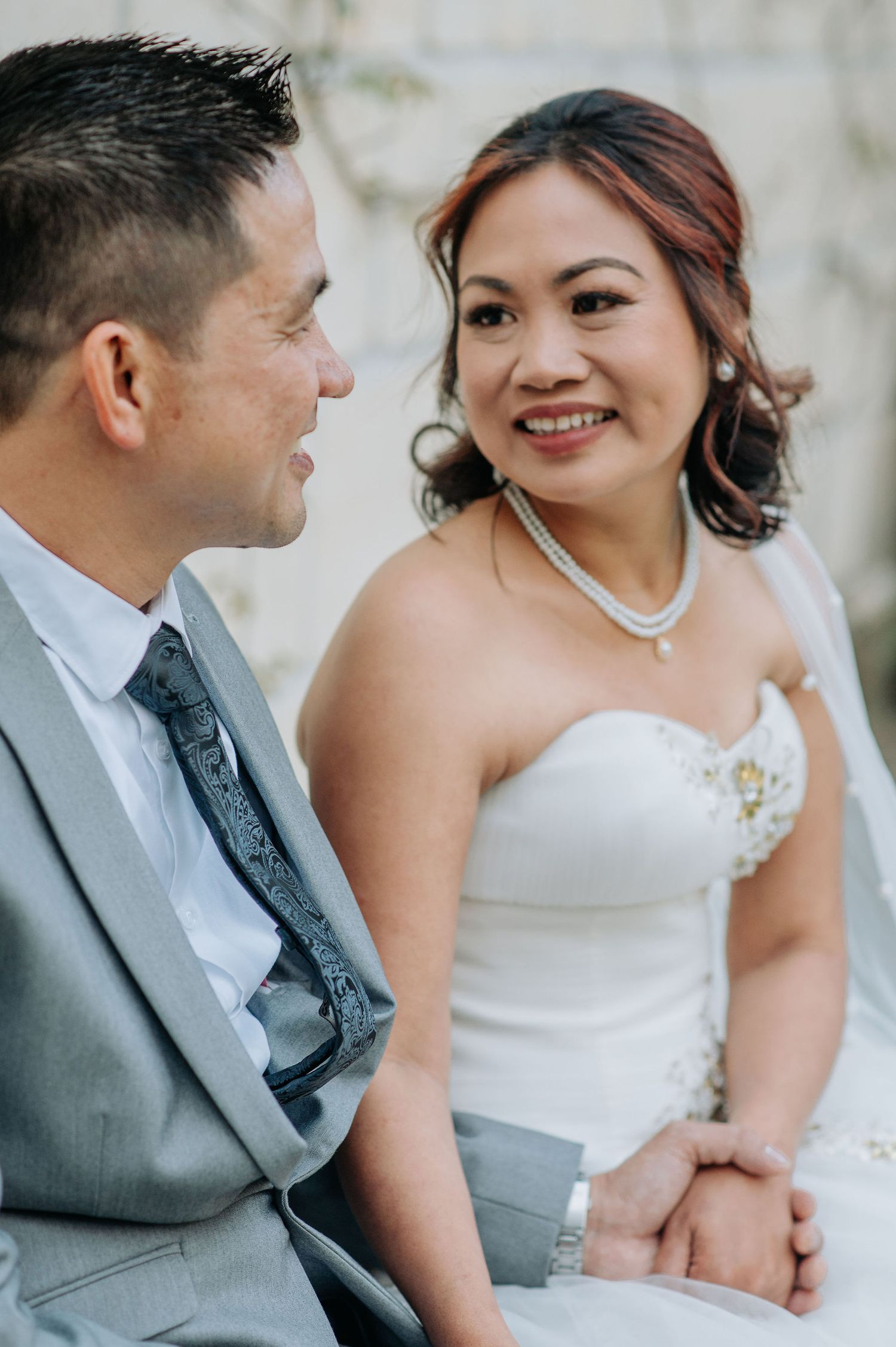 A tender wedding moment captured with a couple in classic gray suit and white gown.