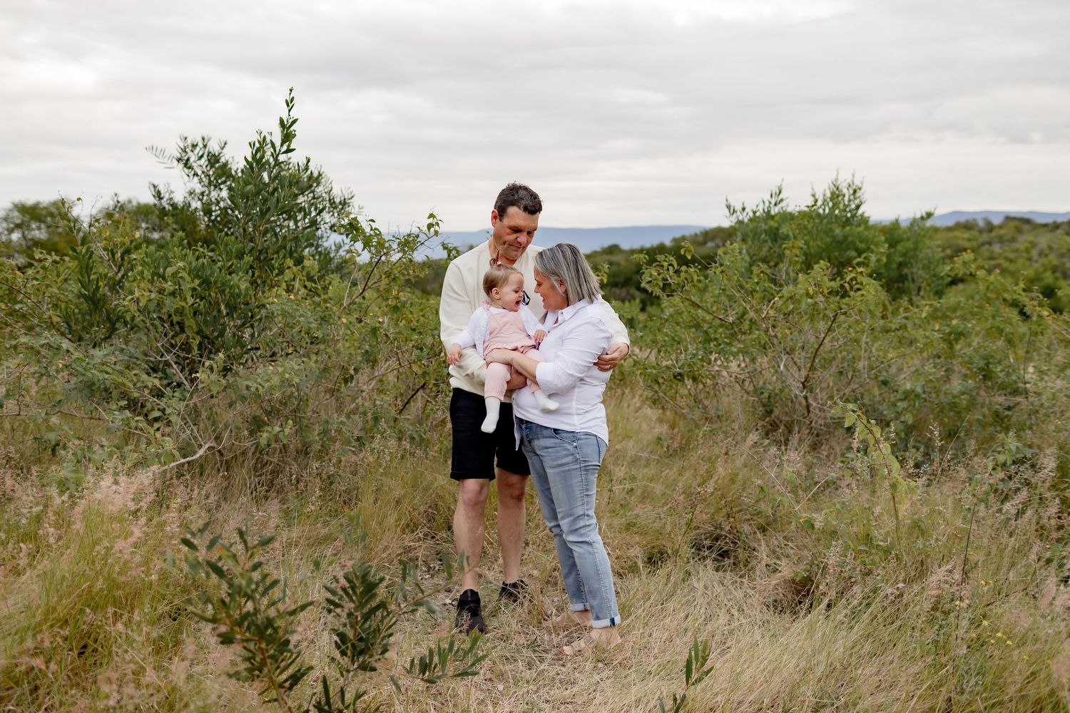 Casual outdoor portrait session in a natural brushland setting.