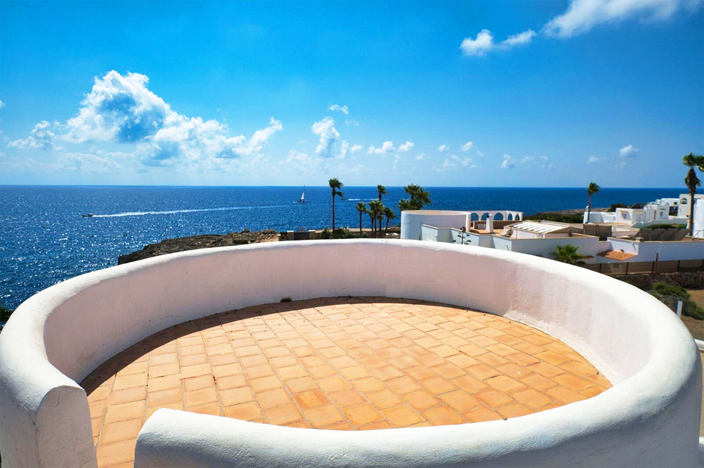 Circular viewing platform with curved white walls overlooking the Mediterranean Sea.
