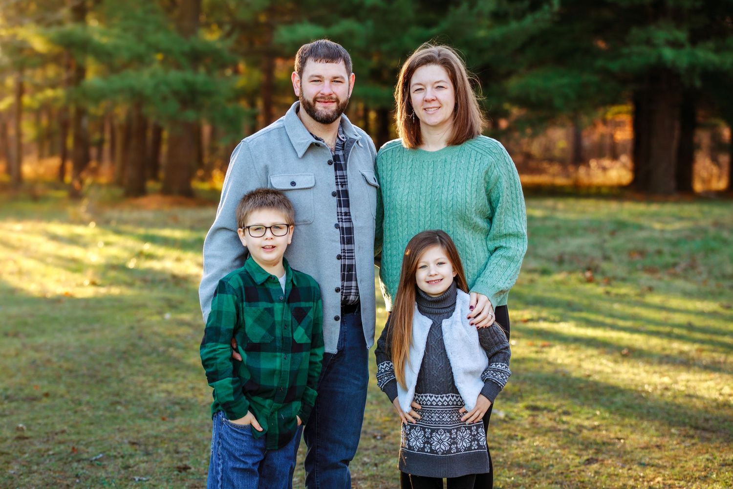 A family of 5 smiling in front of their personal pond.