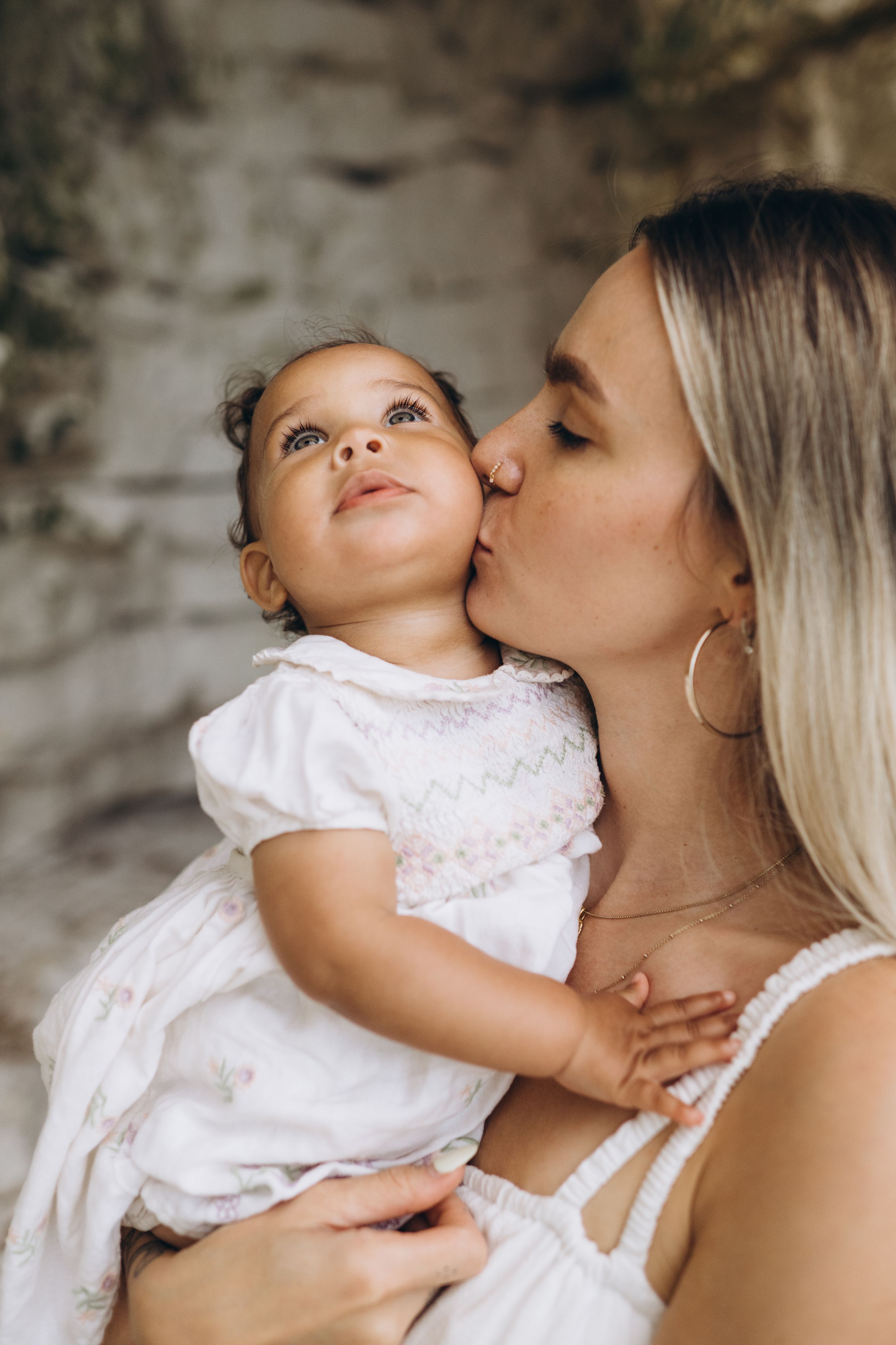 a mother kissing her little girl's cheek by the sea side kent family photographer