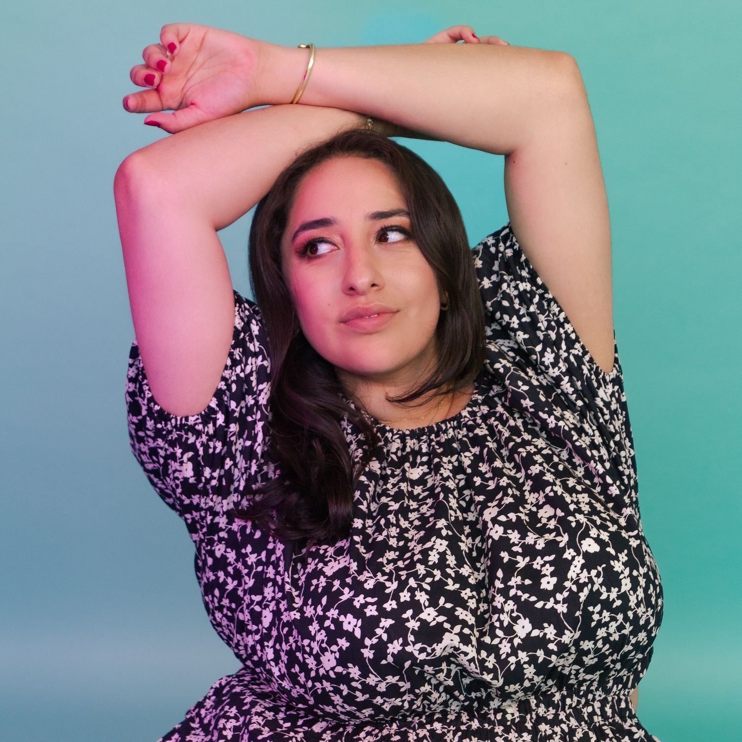 Studio portrait against gradient backdrop with dramatic lighting and floral print dress.