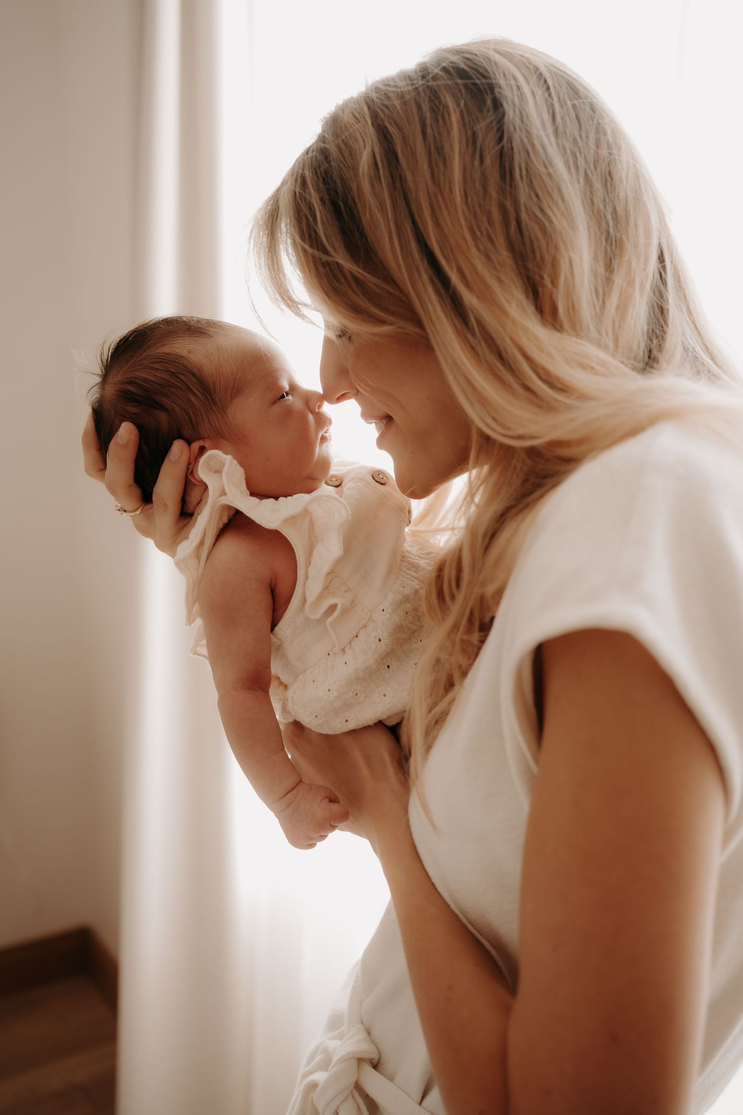 Intimate close-up portrait of parent and baby sharing gentle moments.