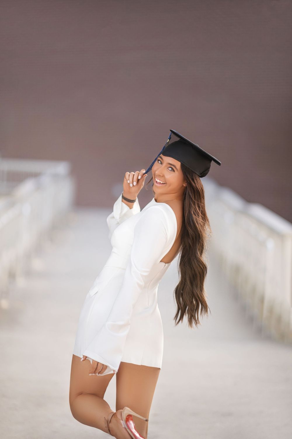 A woman in white attire and black hat poses on the beach in a sequence of shots with soft lighting and sand background.