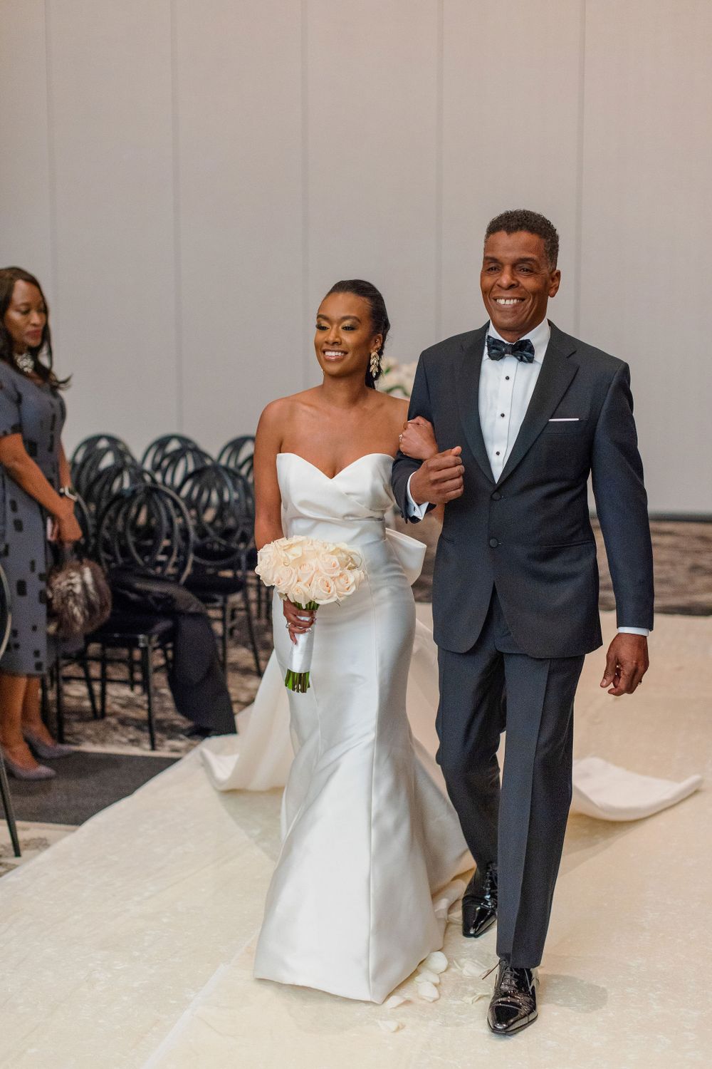 Newlyweds walk down the aisle together at their elegant indoor wedding ceremony.