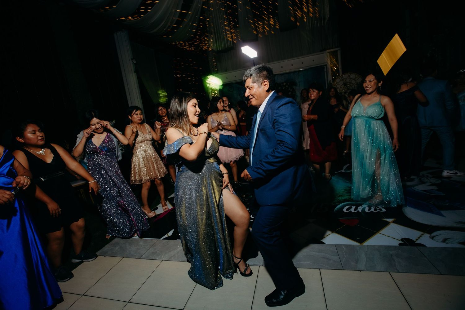 People dancing energetically at a formal evening celebration event on a dance floor.