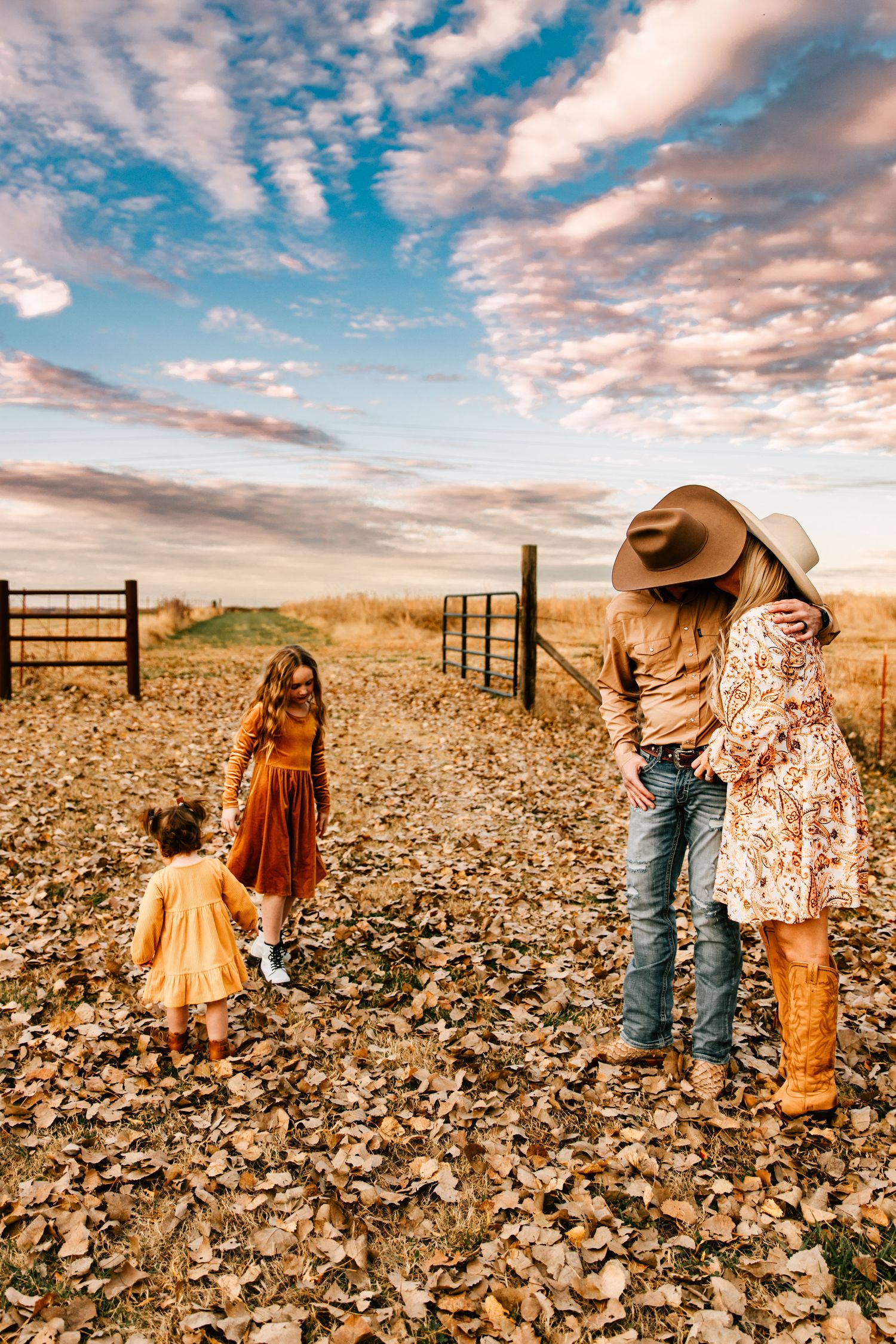 A bold, true-to-color photo of two young sisters and their parents posing at sunset in Kiefer, Oklahoma at Ogie Farms.