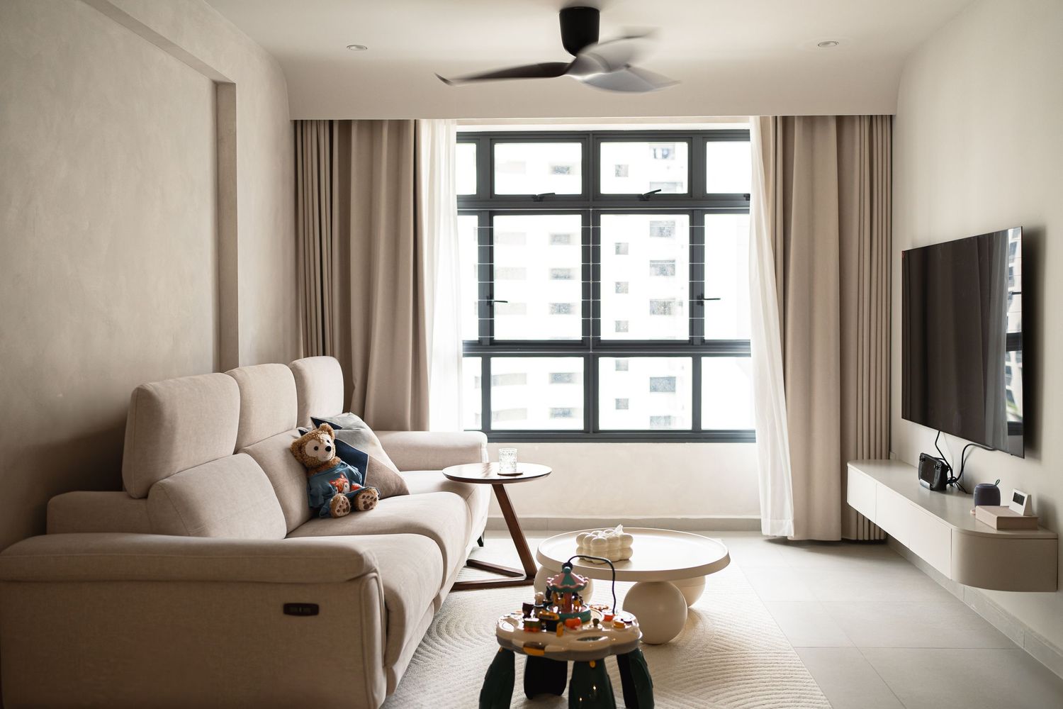 Contemporary minimalist living room with large window and neutral color scheme.
