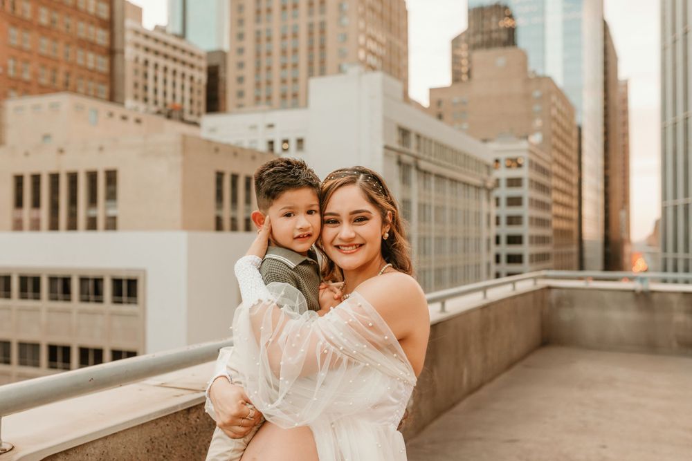 A warm-toned rooftop maternity photoshoot in New York City with architectural backdrop.