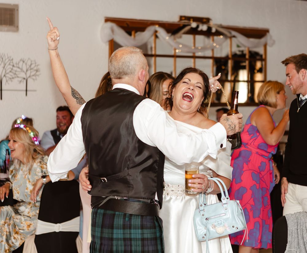 A lively group of people dancing and celebrating together at a social gathering showing joyful movement and energy.