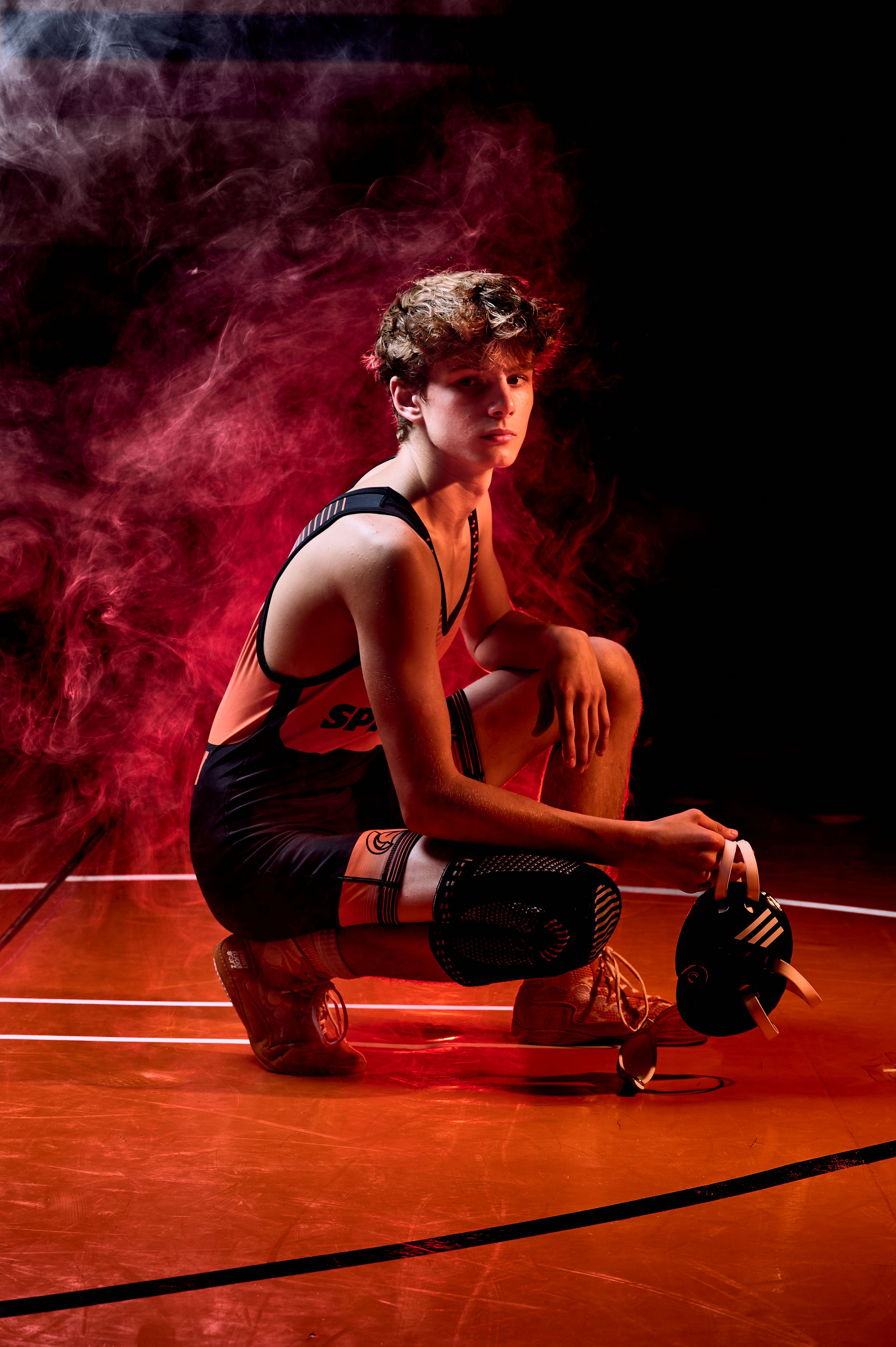 High school wrestler media-day style portrait with dramatic lighting — professional sports photography