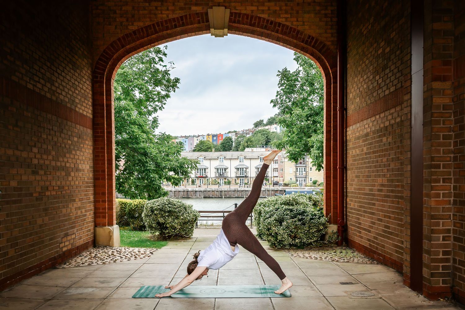 A yoga teacher poses in front of the Hotwells skyline at Baltic Wharf. Natural and relaxed website Bristol brand photography
