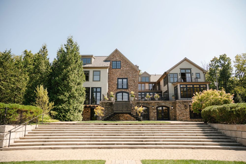 Luxurious multi-level hillside venue with stone facade and grand outdoor staircase surrounded by landscaped gardens.