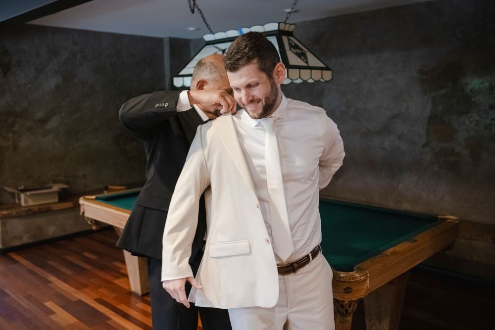 Dad helps the groom put on his jacket before the ceremony.