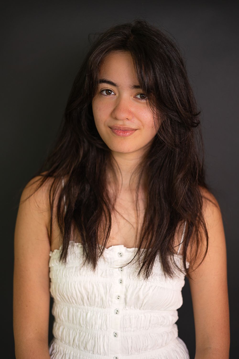 A warm portrait featuring natural lighting and a white button-up dress.