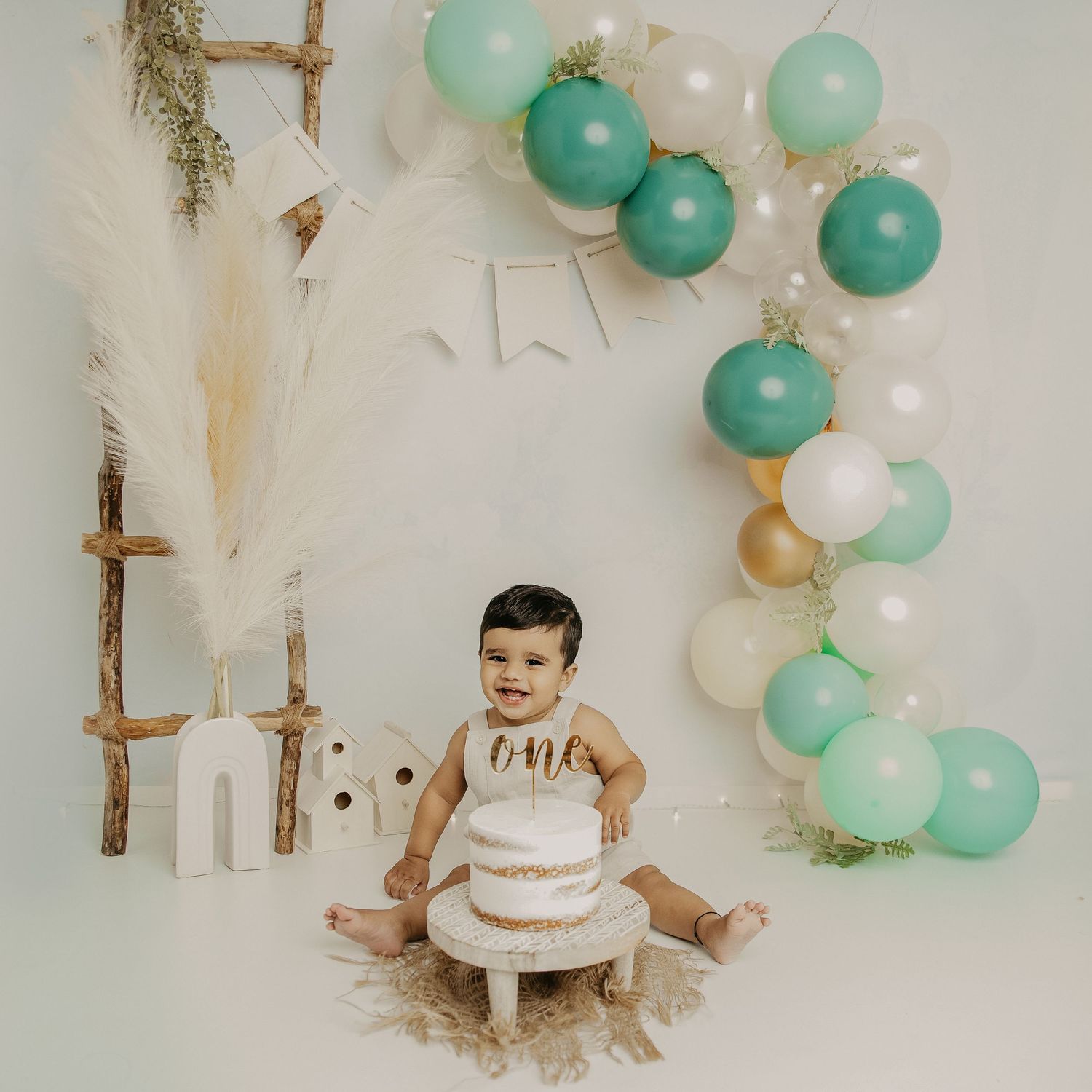 Rustic baby nursery decor with mint green balloon garland, white paper decorations, and wooden ladder accents. Airy and simple photo. Ottawa