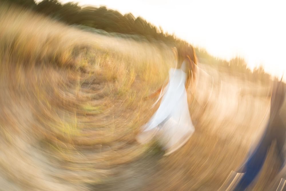 Abstract motion blur photograph capturing swirling golden and brown tones in a circular pattern.