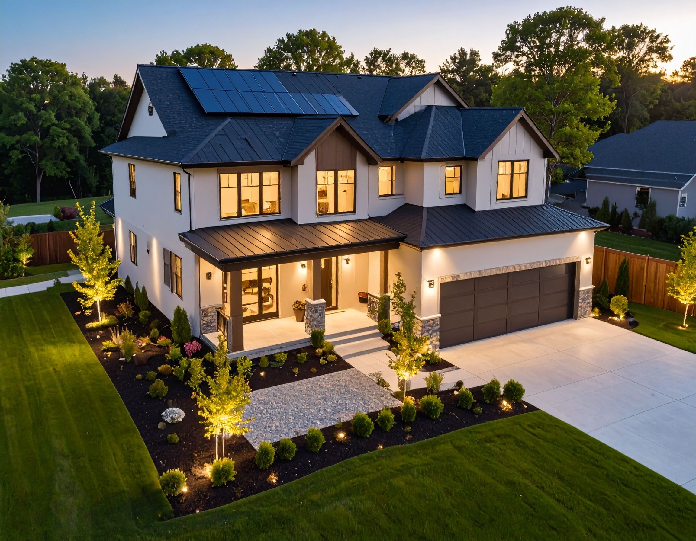 Modern white farmhouse style home exterior with black trim and large windows illuminated at dusk.