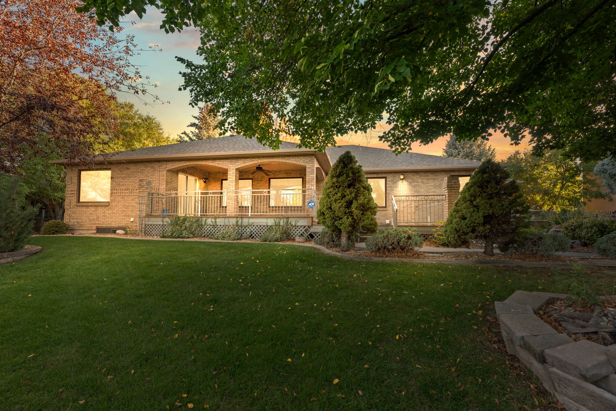 A series of sunset photos showing a ranch-style house exterior with well-maintained landscaping and curved walkways.