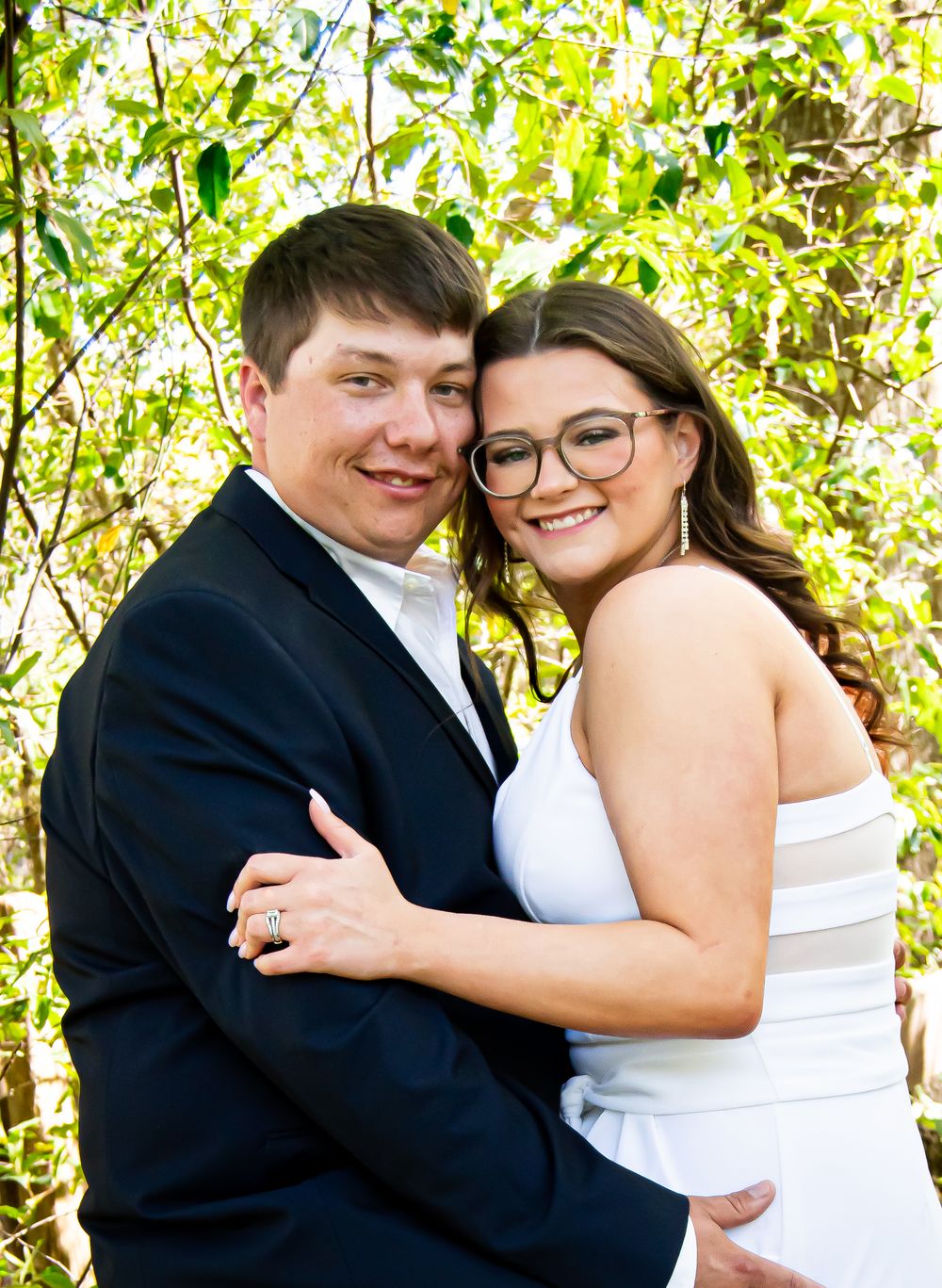 Playful wedding couple shares joyful moments in outdoor garden setting.