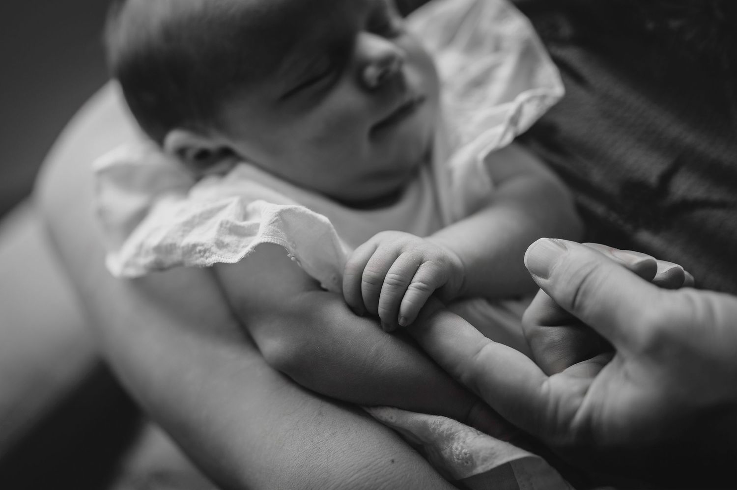 A black and white photo showing hands gently touching and connecting in an intimate artistic composition.