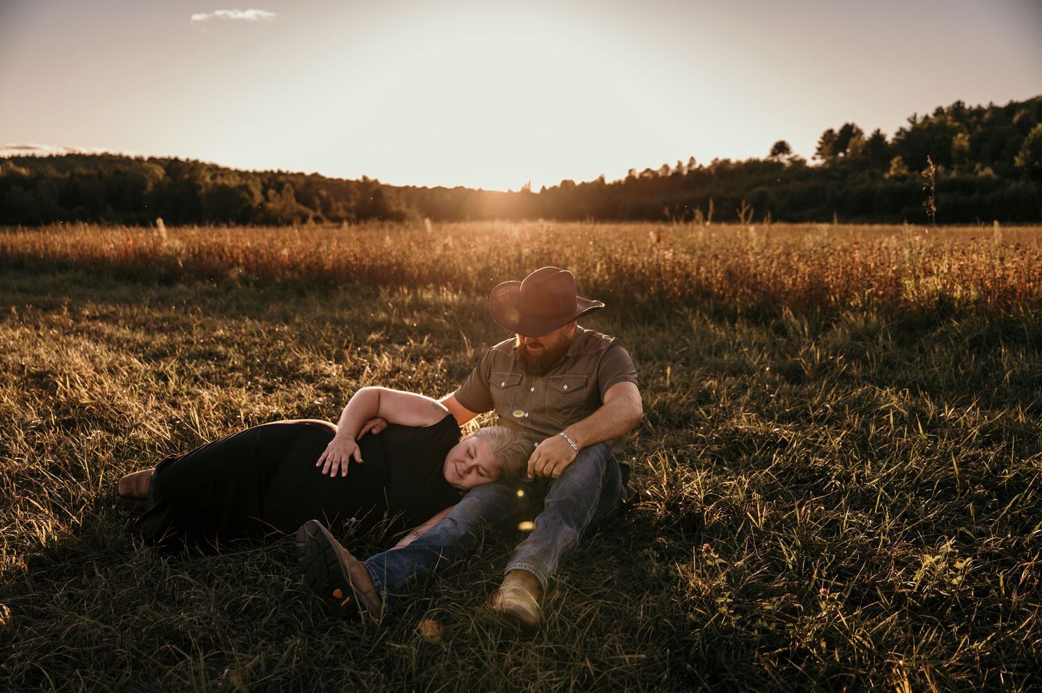 A person lies peacefully in a golden wheat field during sunset with dramatic lighting and long shadows.