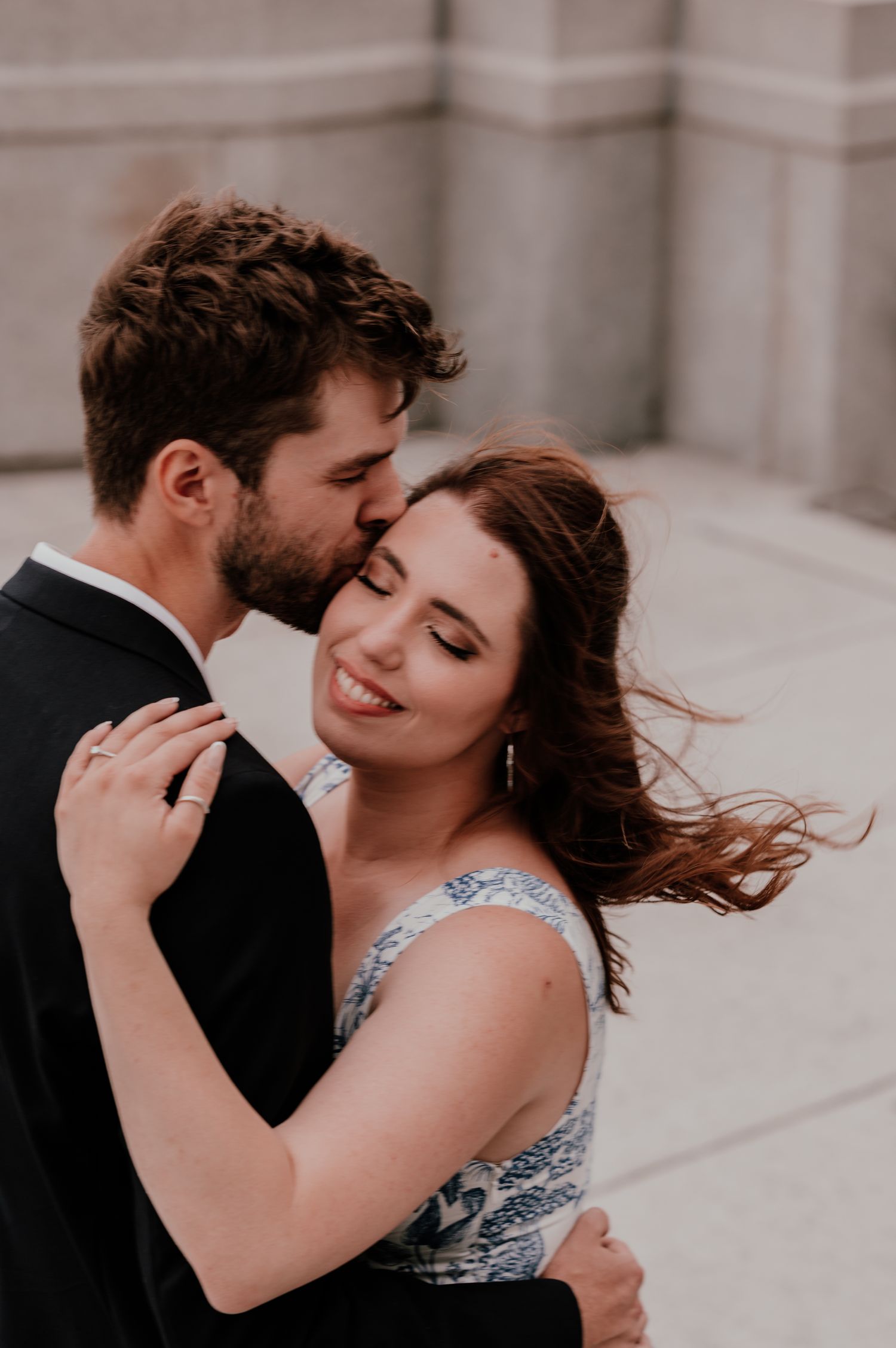 An intimate moment shared between a couple as they embrace on a rooftop terrace.