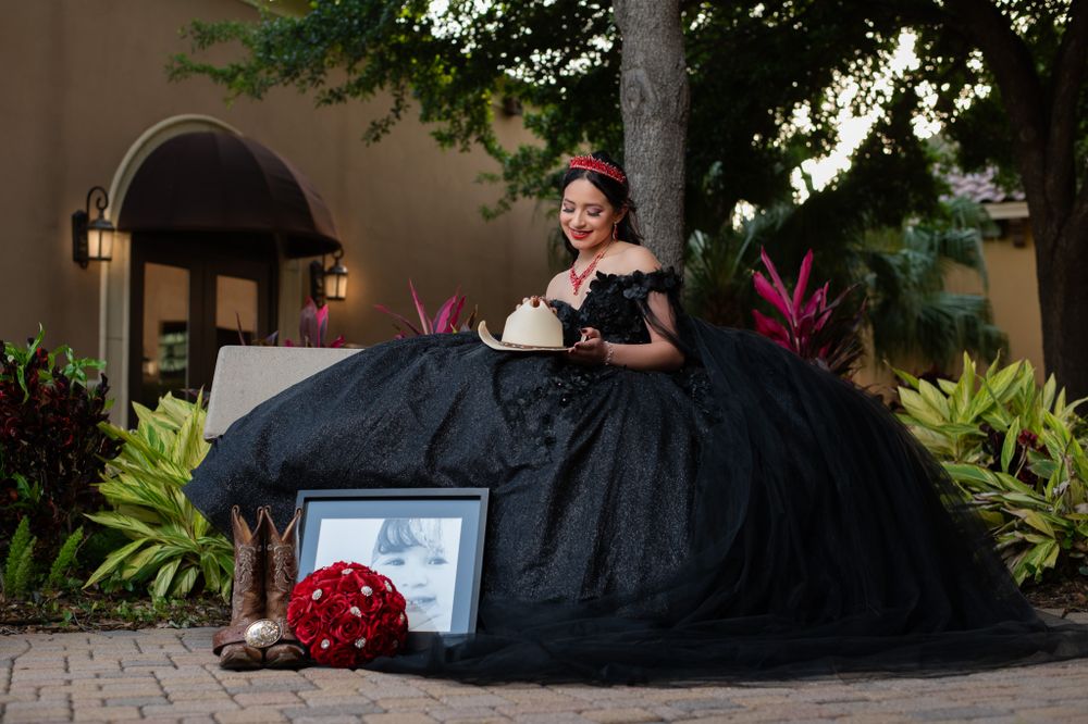 A black ballgown photo session with western accessories and framed photo.
