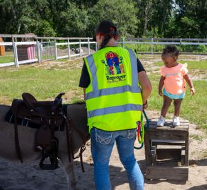 People wearing safety vests working at outdoor stations or tables.