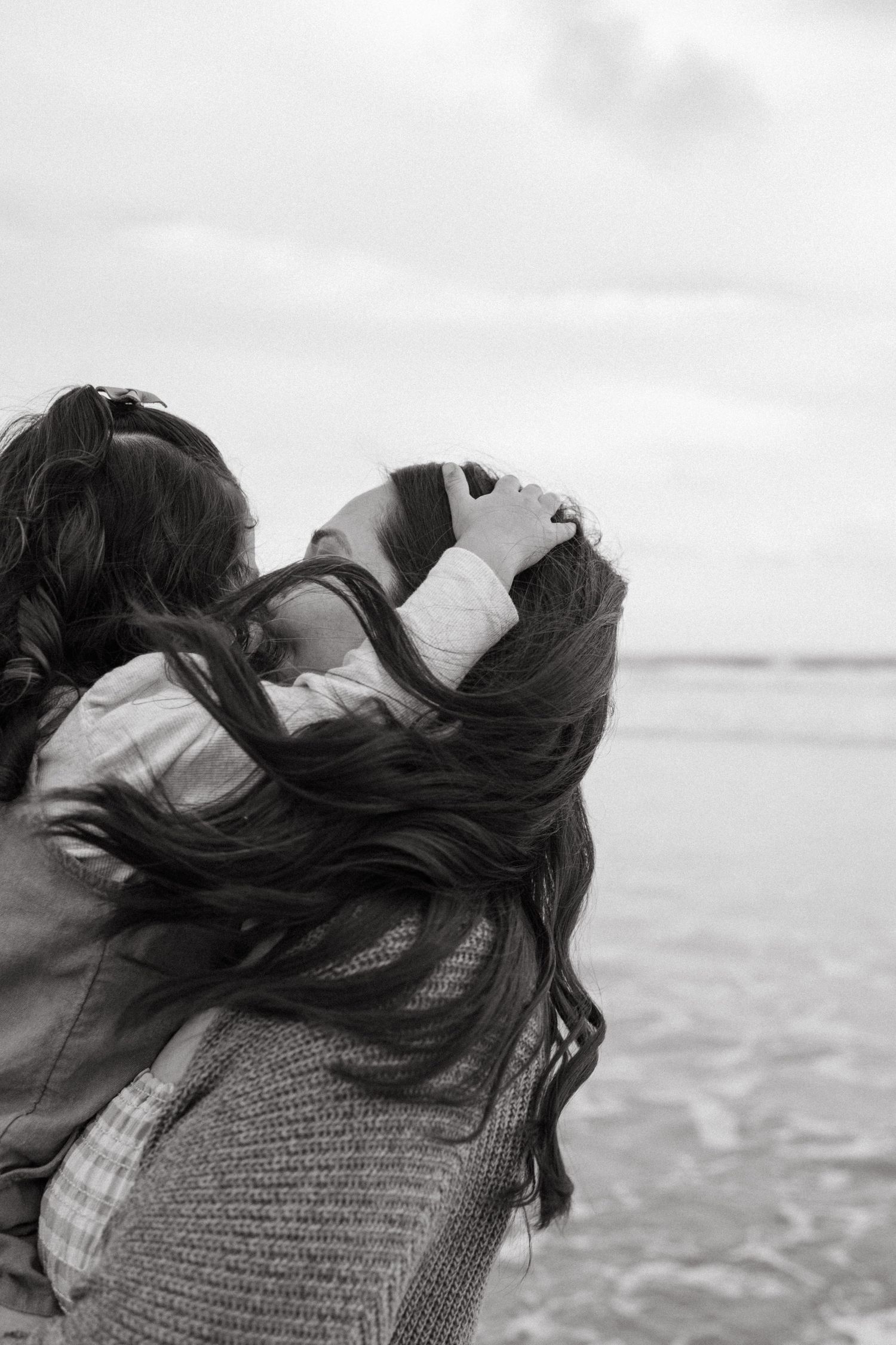 Black and white photo of windswept hair against an ocean backdrop during family photoshoot in San Diego.