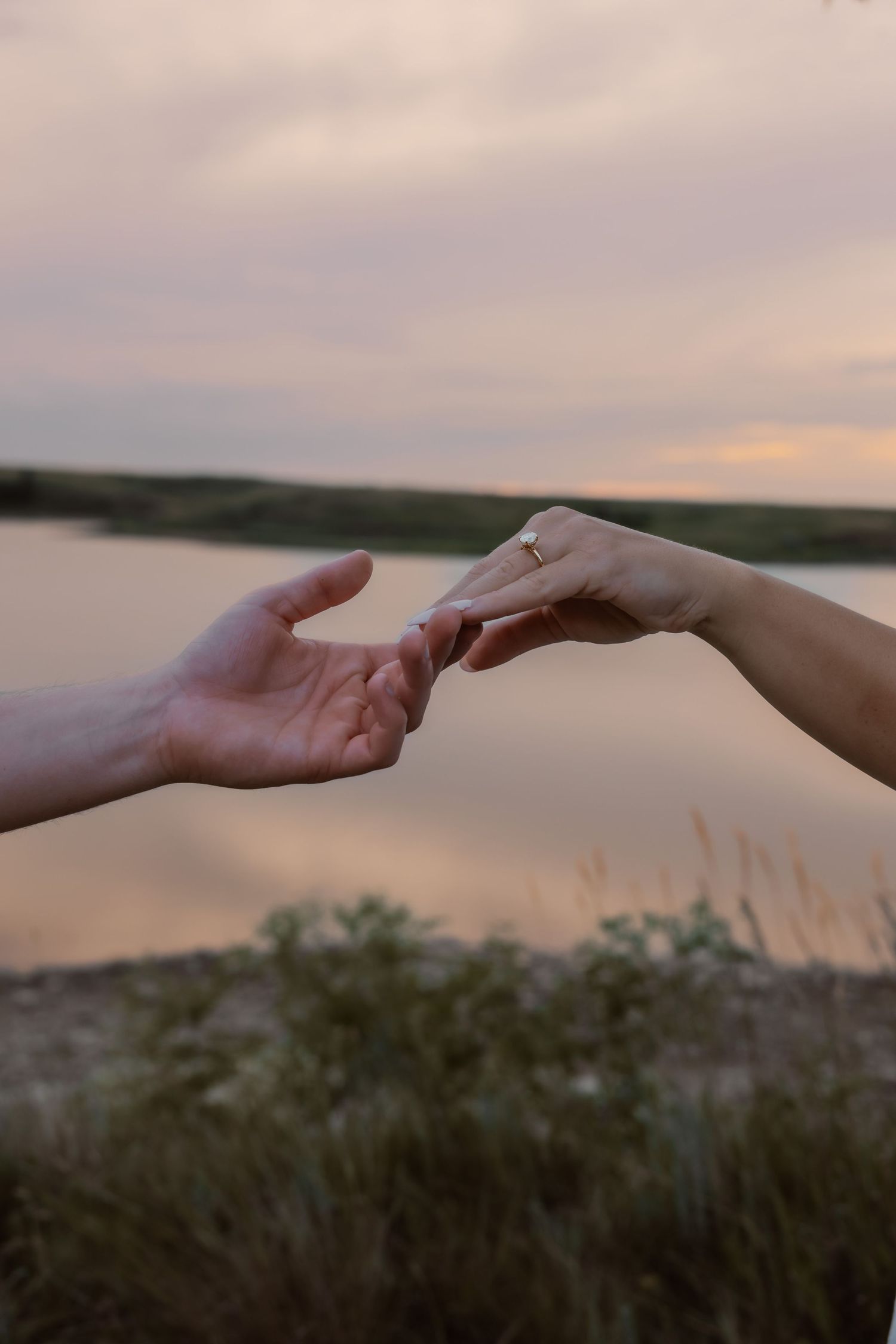 Engaged couple in Bismarck North Dakota gently touching hands during romantic engagement photoshoot