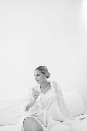 Elegant bridal morning preparation scene in soft black and white tones.