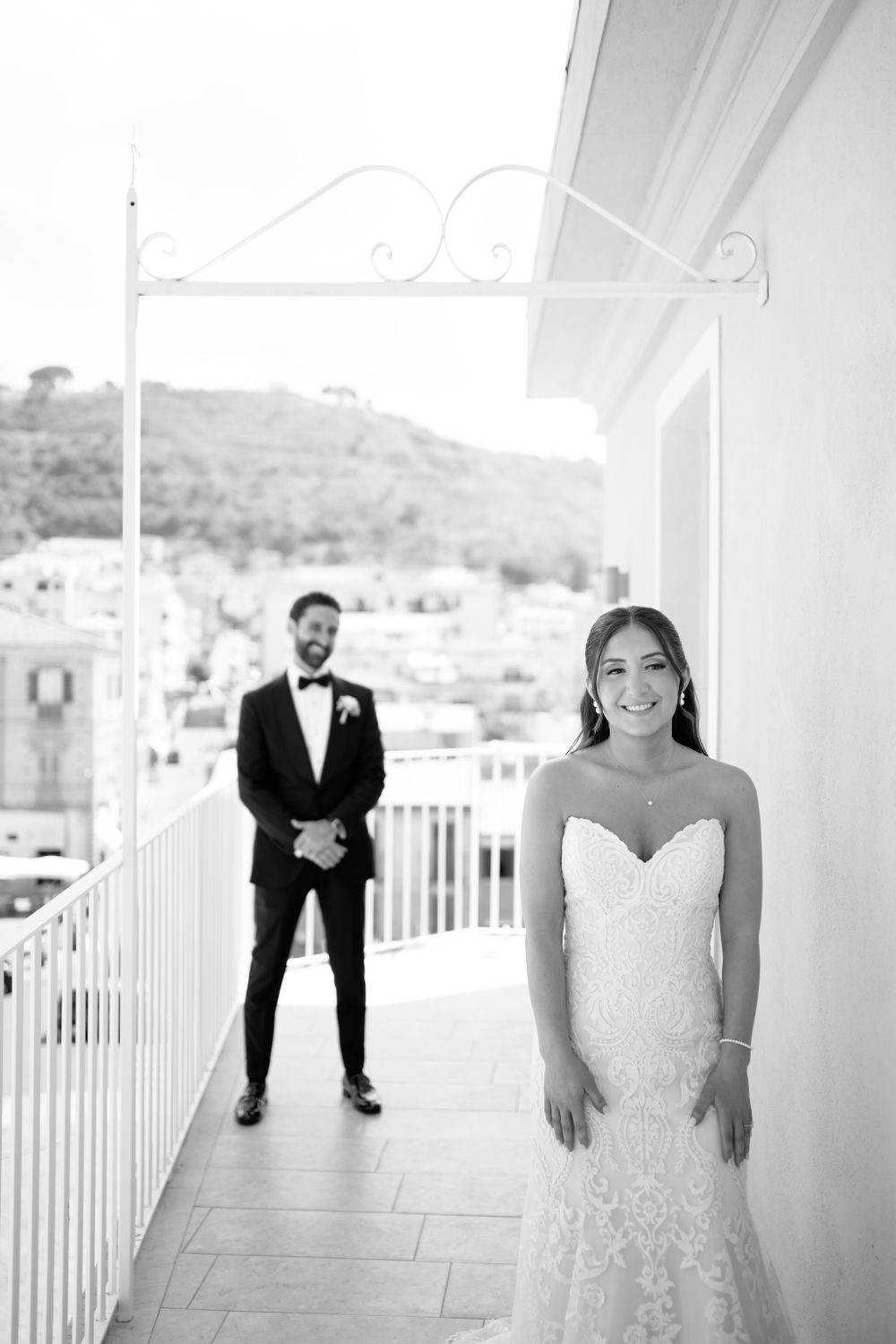 Stylish black and white wedding portrait on scenic Italian balcony.