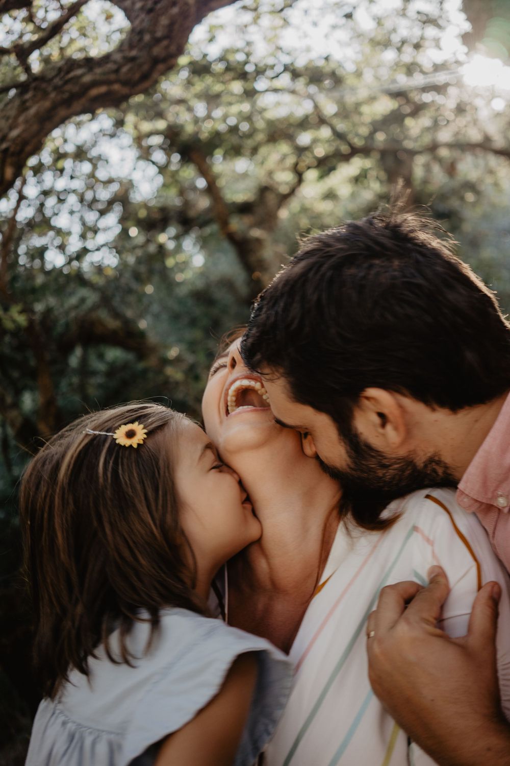 Momentos de ternura e brincadeira em família na natureza. Fotografia espontânea que capta amor, sorrisos e imaginação infantil.