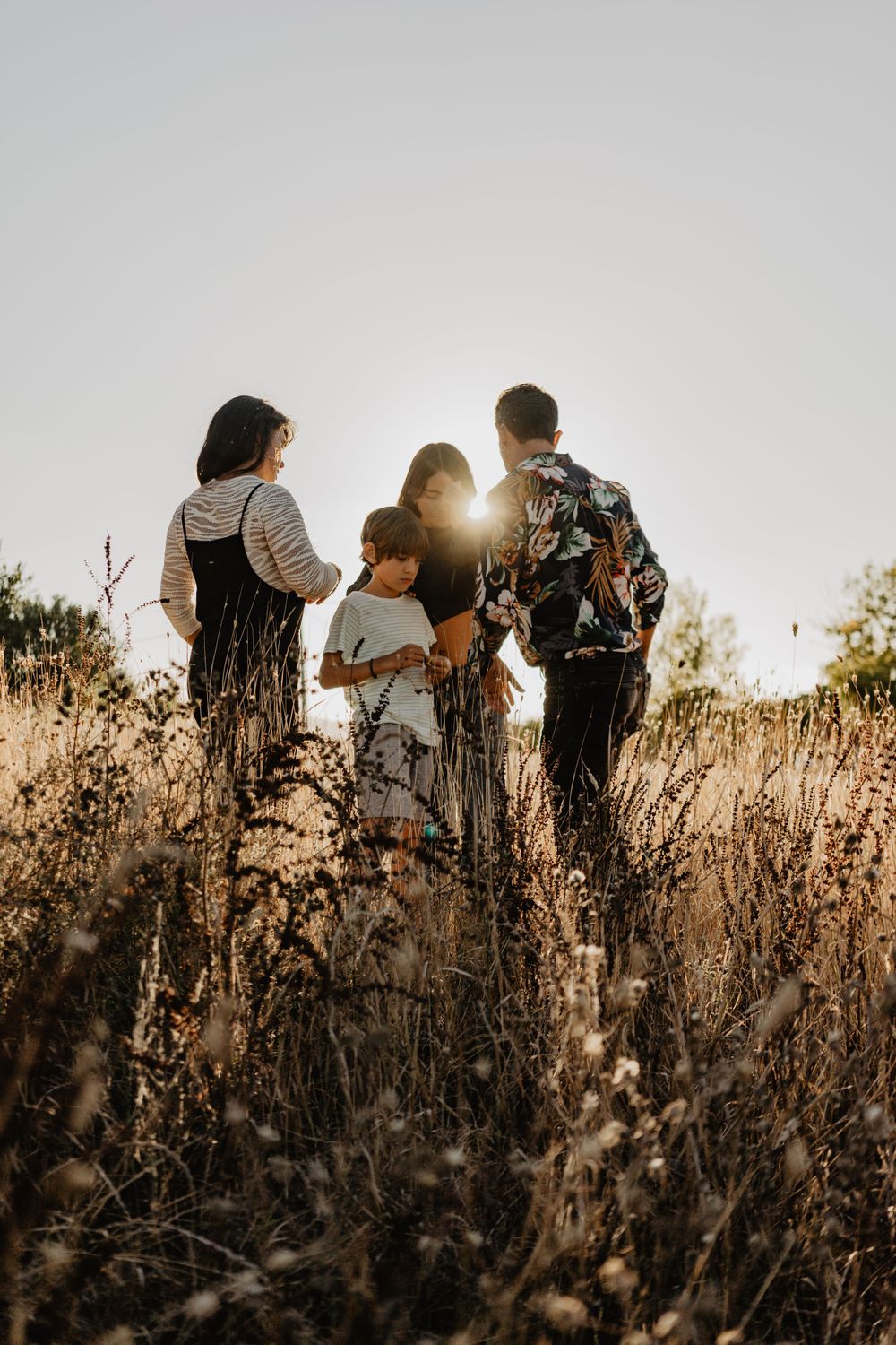 Sessão de família ao ar livre na natureza. Fotografia lifestyle espontânea que capta alegria, movimento e ligação autêntica ao pôr do sol.