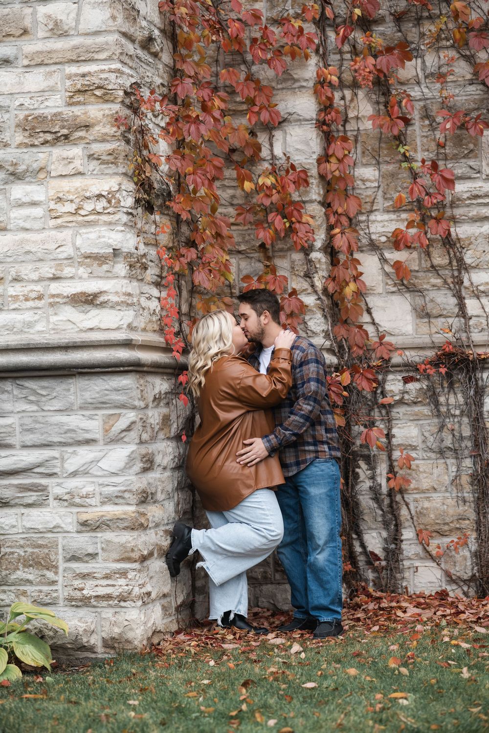 A romantic autumn scene against a stone wall with red ivy vines creating a cozy natural backdrop.